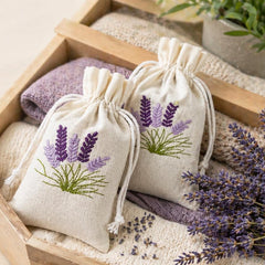 two lavender sachets in a wooden box with lavender flowers and branding text.
